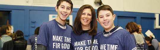 Three volunteers standing together in a community setting