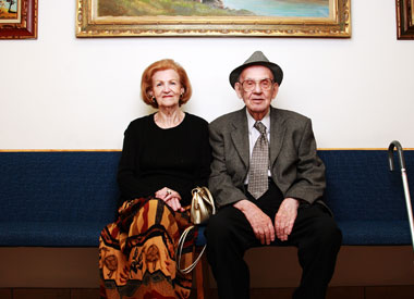 Elderly woman and man sitting next to each other