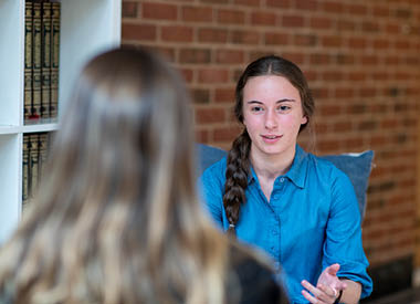 Girl sitting and talking with another person