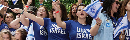 People waving Israeli flags at the Israel Day Parade