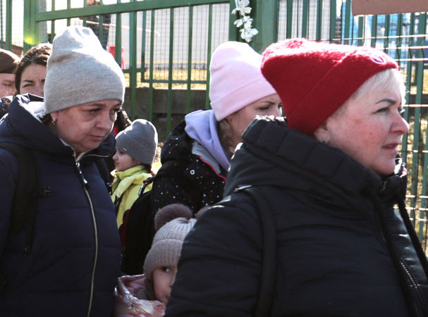 Group of adults and a child wearing coats and hats standing outdoors